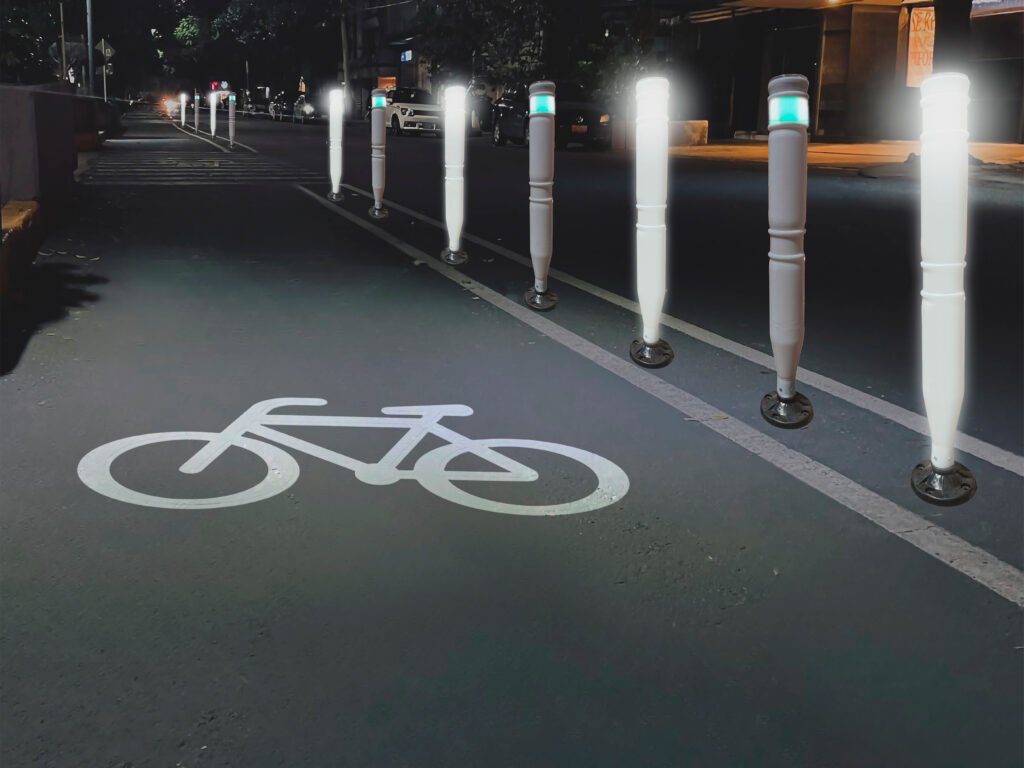 Ciclovía urbana iluminada con balizas reflectantes, un ejemplo de los tipos de ciclovía que priorizan la visibilidad nocturna.