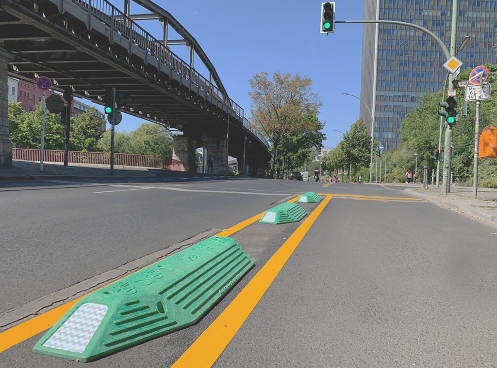 Separadores (confinadores Confibici 40 ) viales instalados sobre carril ciclista, característicos de los tipos de ciclovía canalizada que protegen al usuario del tráfico vehicular.