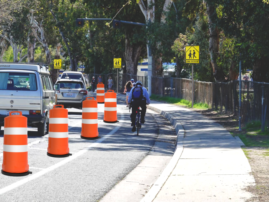 Ciclovía emergente delimitada con trafitambos naranjas y señal de paso escolar, uno de los tipos de ciclovía usados para responder a alta demanda ciclista.