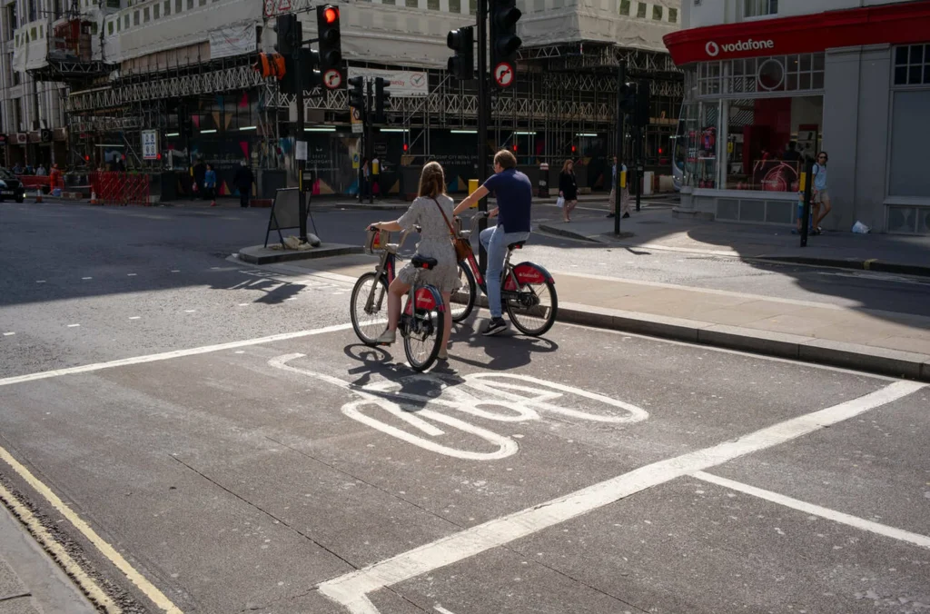 ciclistas en caja de espera ciclista frente a semáforo en intersección urbana