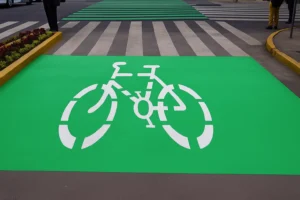 Caja de espera ciclista pintada en verde en un cruce con semáforo, área destinada a dar prioridad y seguridad a ciclistas urbanos.
