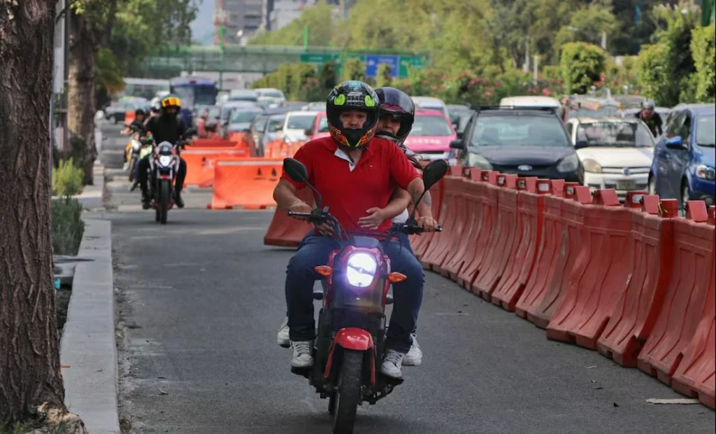 Motociclistas circulando por ciclovía exclusiva en hora pico, ejemplo de invasión de carril ciclista que pone en riesgo a usuarios vulnerables.