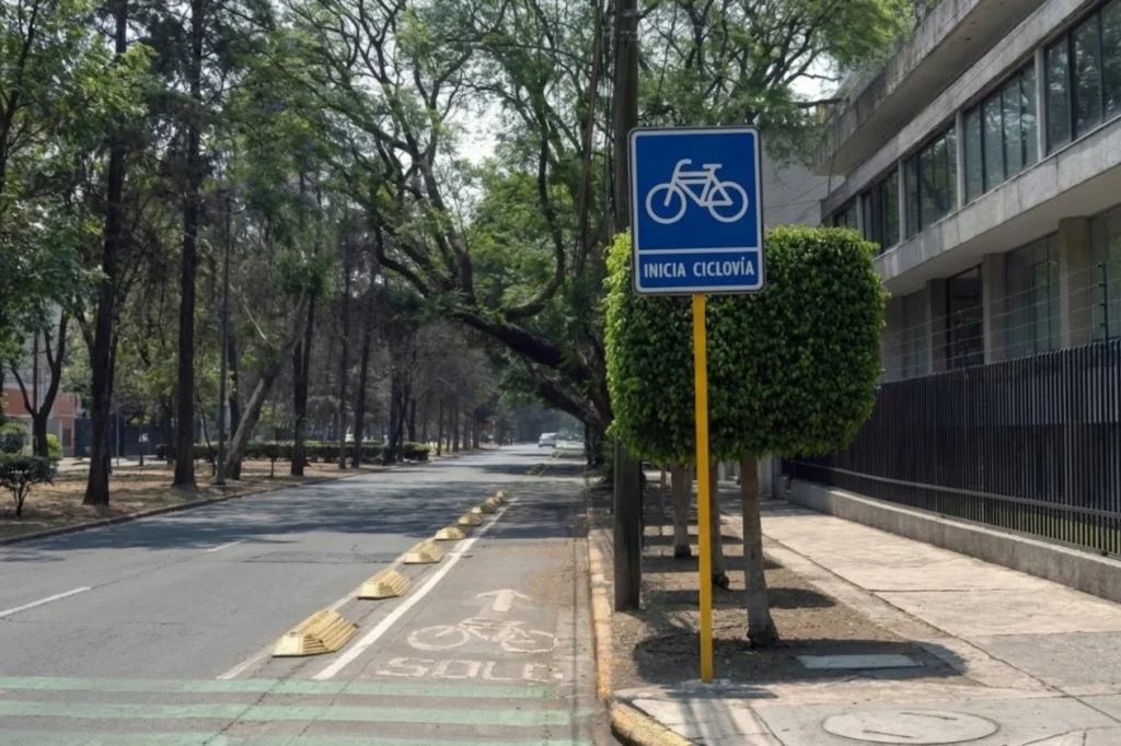Señal que marcan el inicio de una ciclovía en una calle arbolada.